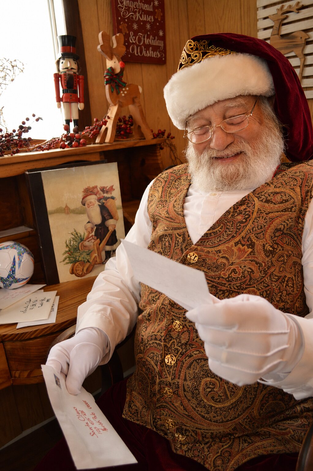 Santa smiling as he reads a child's Christmas letter